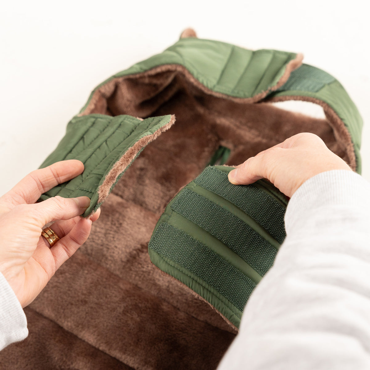 Adjustable hook-and-loop chest and neck straps on the Woodland Green dog puffer coat, with taupe fleece lining