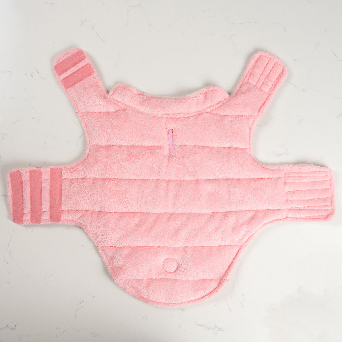 Soft plush pink fleece lining of the Pink Blush dog puffer coat laid flat