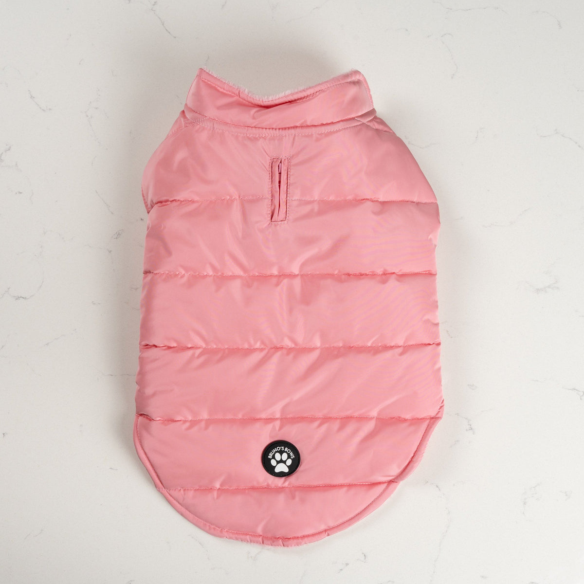 Pink Blush dog puffer coat from above with zipped lead opening and Bruno's Bows badge